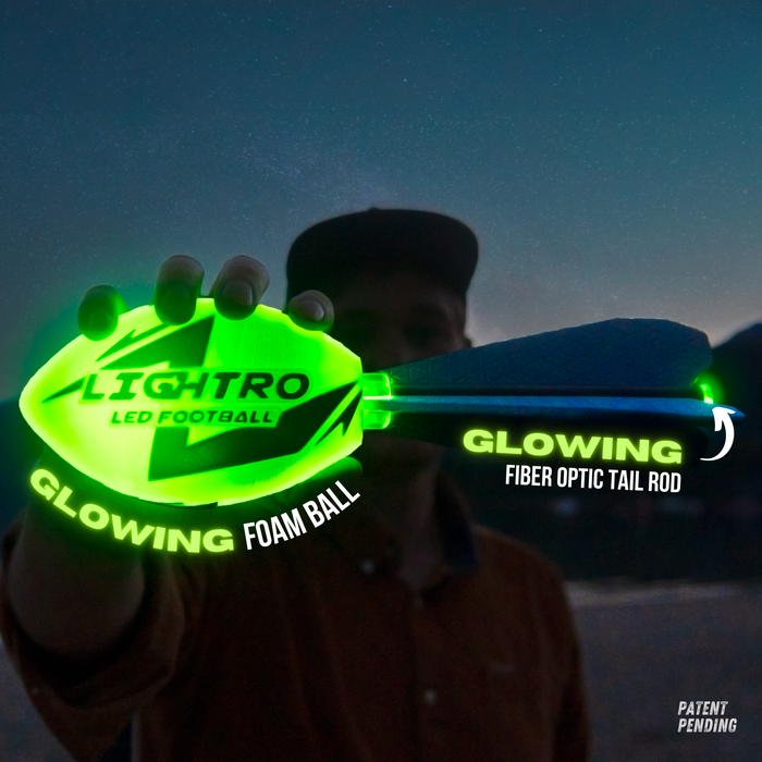 A person holds a glowing green LIGHTRO LED Football with a radiant fiber optic tail, both shining in the dark. The text highlights the Glowing Foam Ball and Glowing Fiber Optic Tail Rod.